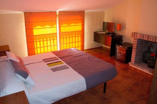比拉法梅斯Casa Rural Magnanimvs的一间卧室设有一张大床和一个壁炉