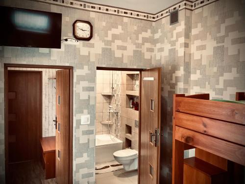 格丁尼亚Pokoje Goscinne Gallick的一间带卫生间和墙上时钟的浴室