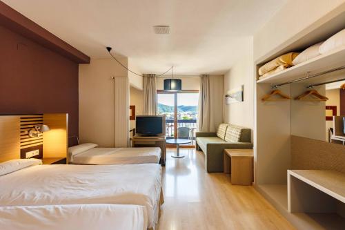 哈卡Oroel Hotel & SPA的酒店客房设有两张床和电视。