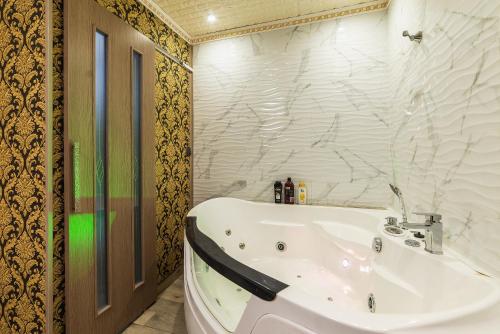 第聂伯罗Смарт Апартаменты джакузи的带浴缸和白色盥洗盆的浴室