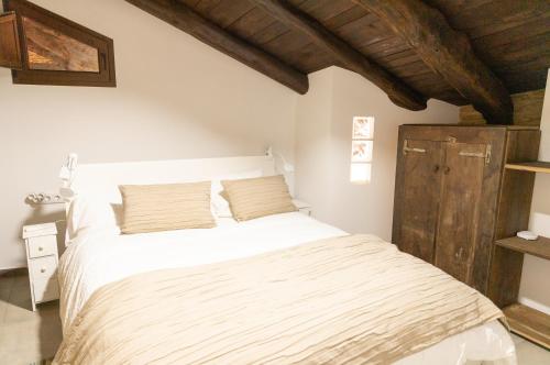 卢戈Finca Eiras的卧室配有白色床和木制天花板