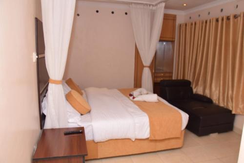 内罗毕Nairobi Glory Palace Hotel Ltd的一间卧室配有一张床、一把椅子和镜子