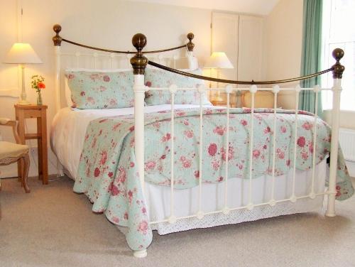 欧克汉普敦Lobhill Farmhouse Bed and Breakfast and Self Catering Accommodation的卧室配有白色华盖床和粉红色的鲜花
