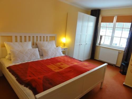 宾茨伊莎贝尔公寓的一间卧室配有一张带红色毯子的大床