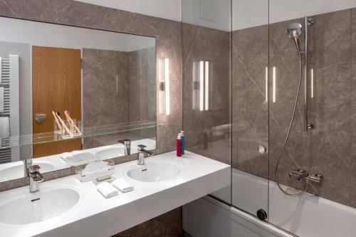 柏林曼陀罗套房酒店的一间带两个盥洗盆和淋浴的浴室