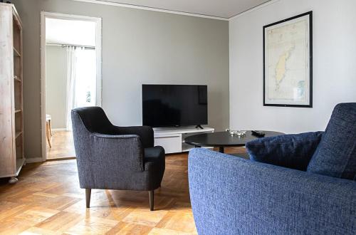 维斯比卡尔奥斯卡尔斯克莱宾公寓的客厅配有电视、2把椅子和1张桌子