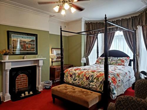 圣约翰斯玫瑰遗产旅馆的一间卧室设有四柱床和一个壁炉