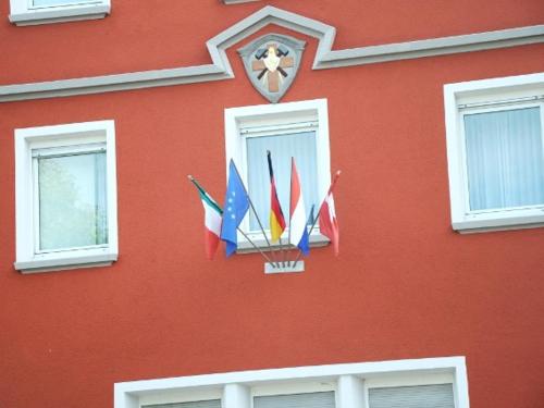 乌尔姆乌尔姆施图本酒店的一座红色的建筑,上面有几个国际国旗