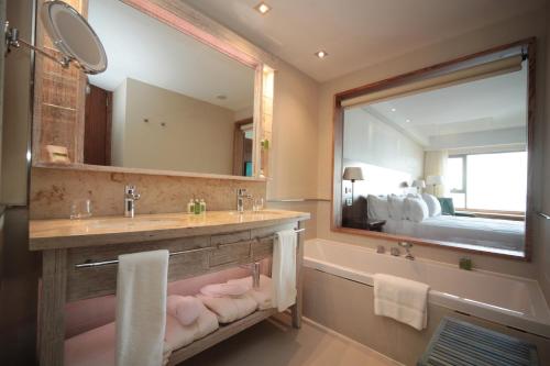 乌斯怀亚乌斯怀亚阿拉酷度假酒店暨Spa的一间带水槽、浴缸和镜子的浴室