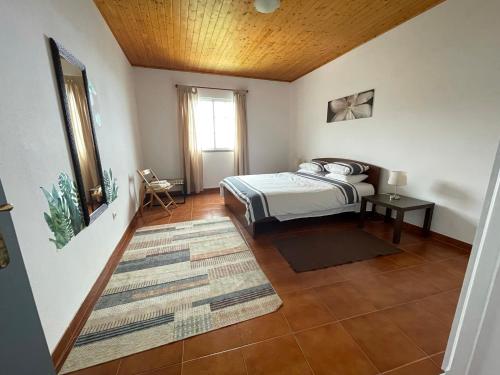 阿科达卡列塔Casa Vista do Ledo的一间卧室设有一张床和木制天花板