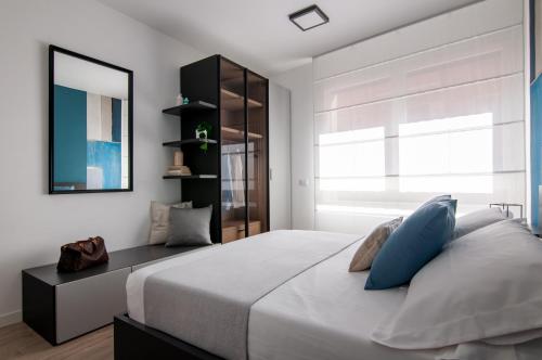 罗马斯卡尔兹公寓的卧室配有带蓝色枕头的大型白色床