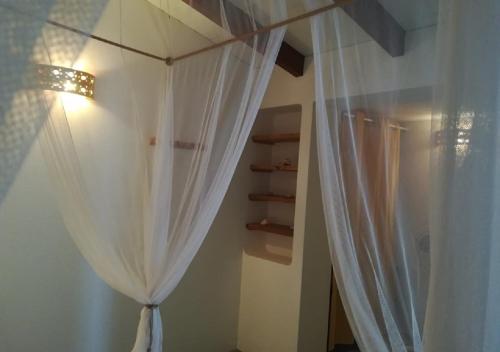 CabeçadasNos Kasa Povoaçao Velha的卧室配有白色窗帘和架子