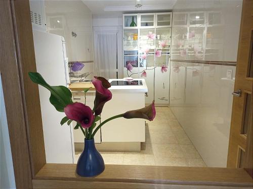 比韦罗A&L Playa的厨房里的一个蓝色花瓶,上面有粉红色的花