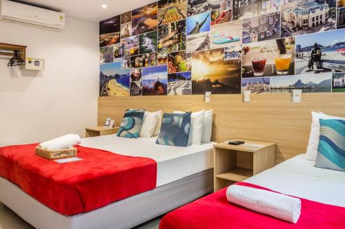 里约热内卢Injoy Suítes & Aparts的墙上有两张照片的房间的床铺