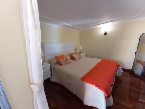 Barranco HondoCamino Real的一间卧室配有一张白色的床和橙色毯子
