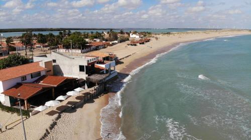 加利纽斯Pousada O Mineiro - frente a praia的享有海滩的空中景致,设有房屋和海洋