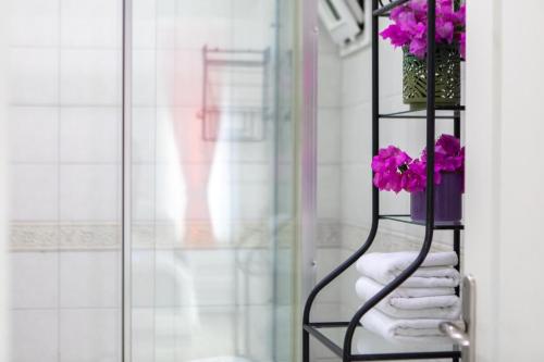 BeldibiOlya Boutique Hotel的浴室内带毛巾和鲜花的毛巾架