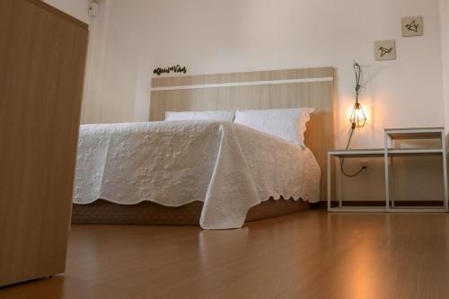 帕苏丰杜Belo Apartamento Central Master Collection的卧室配有带白色棉被的床