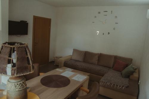 普卢日内Apartment Silence的客厅配有沙发和墙上的时钟