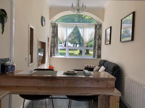 卡洛Cut Limestone Apartment Riverside Lodge的客厅配有桌子和窗户