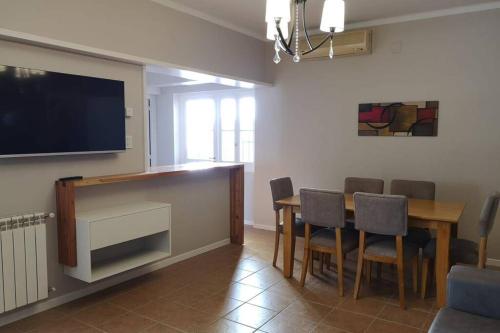 门多萨Precioso Departamento - Excelente ubicación的一间设有桌子的用餐室和墙上的电视