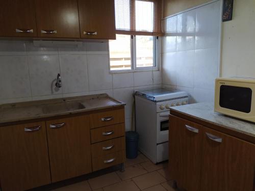 巴拉德尔楚Casa cómoda en Barra del Chuy, Uruguay的一间带水槽和微波炉的小厨房