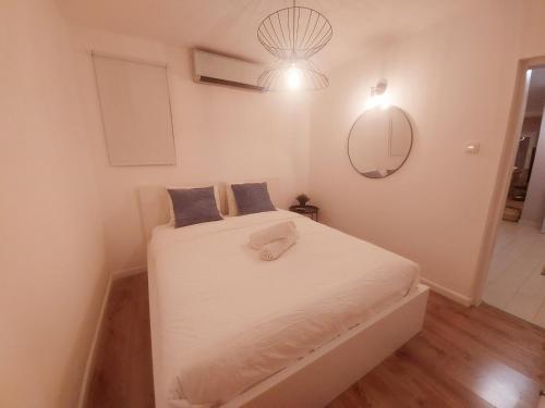 埃拉特Eilat vacation house דירות נופש אילת的一间卧室配有一张带白色床单和镜子的床