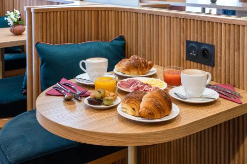 巴黎O.Lysée Hotel的一张桌子,上面放着羊角面包和咖啡