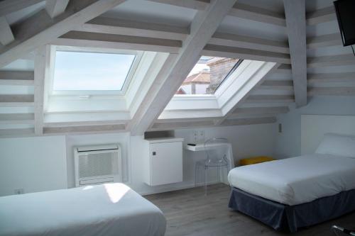 圣地亚哥－德孔波斯特拉Hotel Alda San Bieito的一间卧室设有两张床和两个窗户。