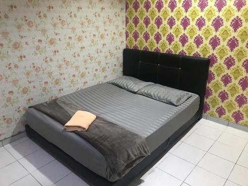 卢穆特No 96 Nazirin Homestay Lumut的卧室内一张带黑色床头板的床
