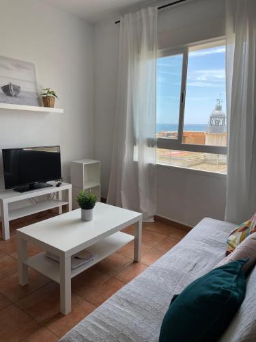 加鲁查Apartamento y Piso frente al mar con vistas en Garrucha的带沙发、桌子和窗户的客厅