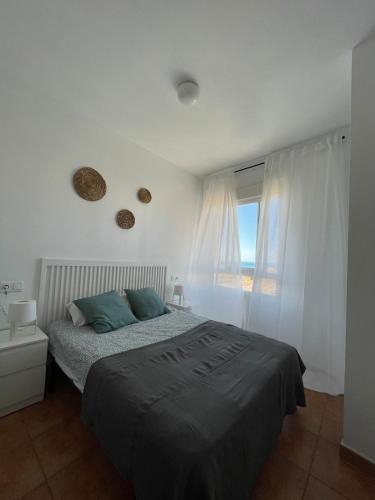 加鲁查Apartamento y Piso frente al mar con vistas en Garrucha的一间卧室设有一张床和一个窗口