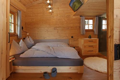 基姆湖畔贝尔瑙Das Alm-Chalet-Chiemsee的小木屋内一间卧室,配有一张床