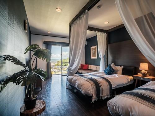 石垣岛ザ・ビーチテラスホテルアオ石垣的酒店客房设有两张床和盆栽植物