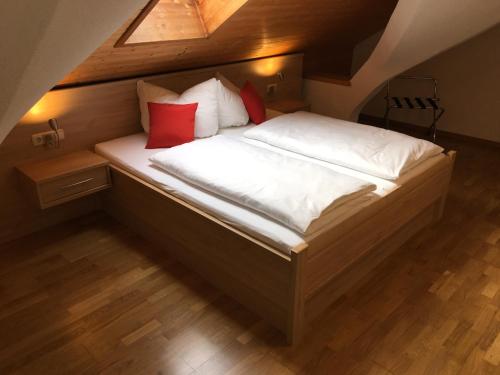 亚亨瑙Hotel im Sonnental的一张带红色和白色枕头的床