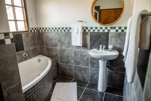 赫卢赫卢韦Duiker Game Lodge的浴室配有盥洗盆、浴缸和盥洗盆