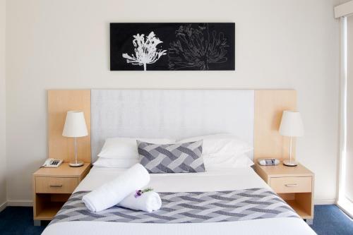 巴特曼斯贝科里甘斯湾酒店的卧室配有带两盏灯的白色床