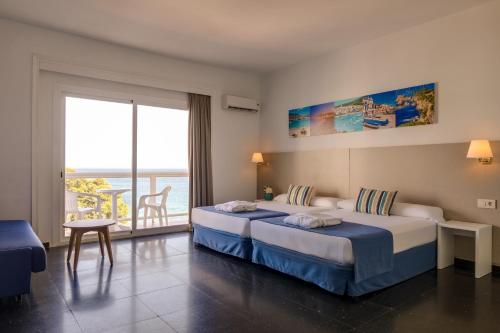 普拉加德阿罗htop Caleta Palace #htopBliss的酒店客房设有两张床和一个阳台。