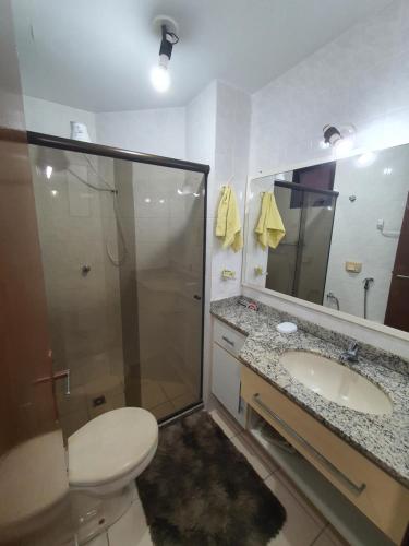 瓜拉派瑞Apartamento quadra praia com vista mar的带淋浴、卫生间和盥洗盆的浴室