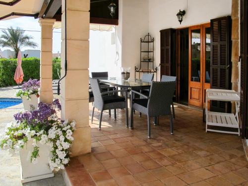 Cala MendiaHoliday Home Dolce Farniente - PCN130 by Interhome的庭院里的餐桌和椅子