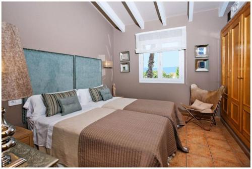 比尼贝卡BINI CEL for 6 pax Heated Pool on request的一间卧室设有两张床、一把椅子和一个窗户。