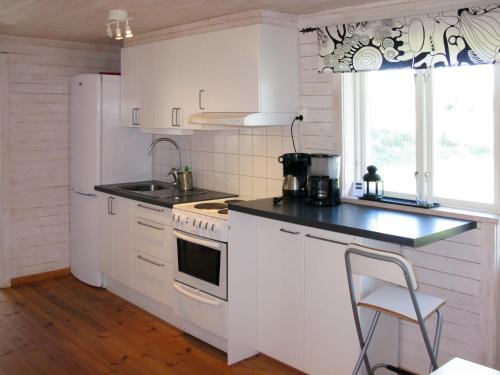 KisaChalet Grönede - OST006 by Interhome的白色的厨房配有炉灶和水槽