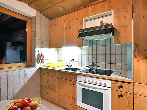 RodundApartment Ainhauser-2 by Interhome的厨房配有木制橱柜和炉灶烤箱。