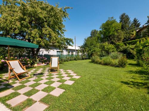 弗留利地区圣达尼埃莱Holiday Home Casa Con Le Rose by Interhome的草坪,带两把椅子和棋盘