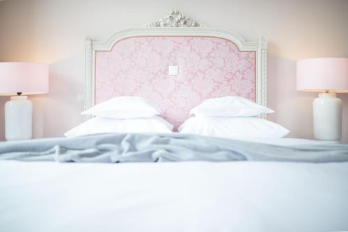 班贝格班贝格霍夫贝尔维尤酒店的一间卧室配有一张带粉红色床头板和枕头的床。