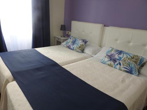 阿利坎特Habitaciones Amelia的一张配有蓝色和白色床单及枕头的大床