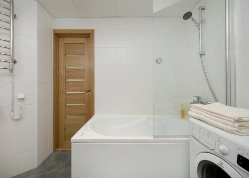 塔林Cozy Lootsi Residence with Sauna and Balcony - Tallinn city centre的带浴缸和洗衣机的白色浴室