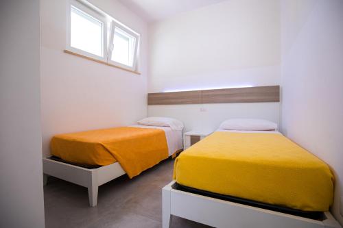 托雷桑塔萨宾娜Donnosanto Residence Pantanagianni的一间卧室设有两张床和窗户。