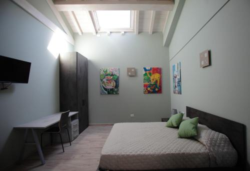 图斯卡尼亚La CASA DEGLI ARTISTI的一间卧室配有一张带绿色枕头的床和一张书桌