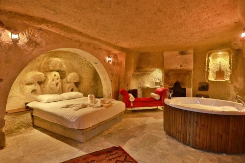 内夫谢希尔Cappadocia Eagle Cave Inn的一间卧室配有一张床和浴缸